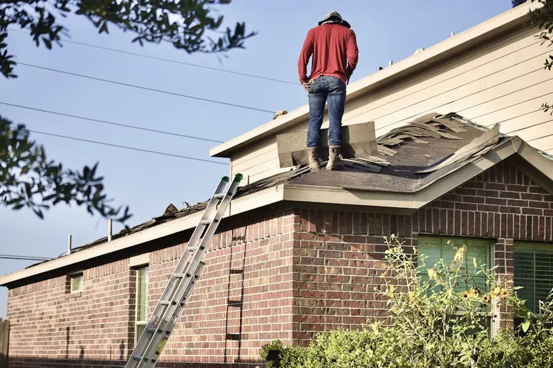 Professional roofer working on a residential roof in Lefferts Mill